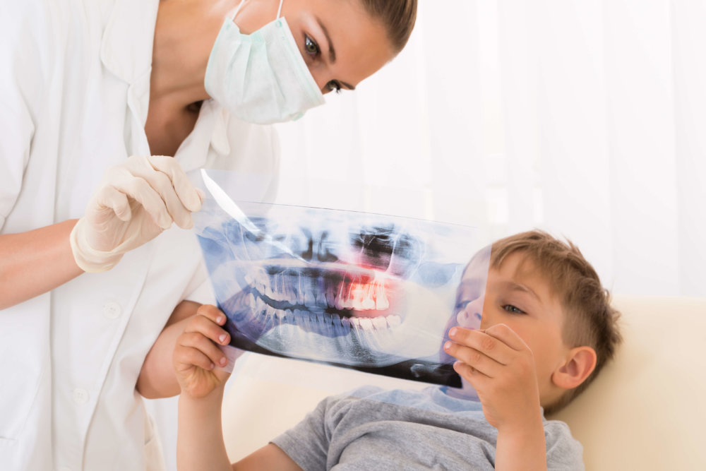 Orthodontist explains braces treatment to a child